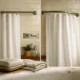 Baño iluminado con comparación de rejas fijas y de ballesta; ambiente cálido y práctico, ideal para un hogar.